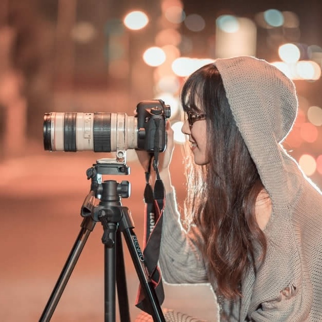 Photo d'une photographe entrain de capturer une scène avec son appareil sur trépied